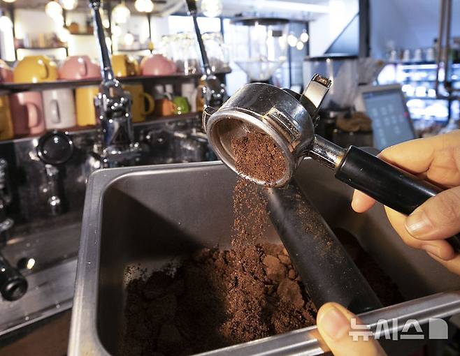 [서울=뉴시스] 조수정 기자 =2022년 3월 15일 서울 종로구 한 카페 운영자가 커피 원두를 내린 뒤 남은 커피박을 모으고 있다. 2022.03.15. chocrystal@newsis.com