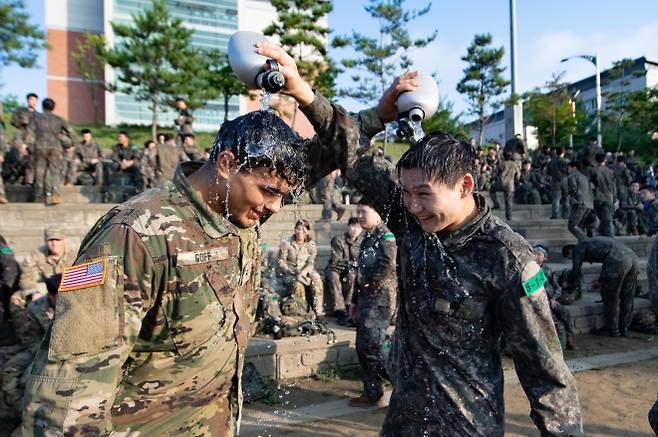 육군, 한미 ROTC 사관후보생 동반훈련 - 육군이 지난 7일부터 8일 충북 괴산 육군학생군사학교에서 ‘한미 ROTC 사관후보생 동반훈련’을 실시했다고 8일 밝혔다. 사진은 양국의 후보생들이 서로 수통의 물을 이용해 무더위를 견디고 있는 모습. 2025.8.8 육군 제공. 연합뉴스