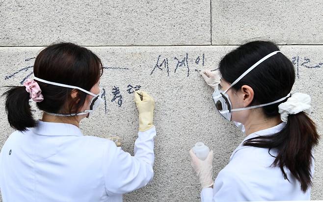 국립고궁박물관 관계자들이 11일 서울&nbsp;경복궁&nbsp;광화문 석축에 쓰인 낙서를 제거하고 있다. ⓒ연합뉴스