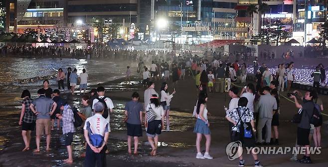 휴일 밤 광안리해수욕장 (부산=연합뉴스) 강선배 기자 = 후텁지근한 더위가 이어진 10일 밤 부산 수영구 광안리해수욕장에서 드론쇼를 관람한 시민과 관광객들이 더위를 식히고 있다. 2025.8.10 sbkang@yna.co.kr