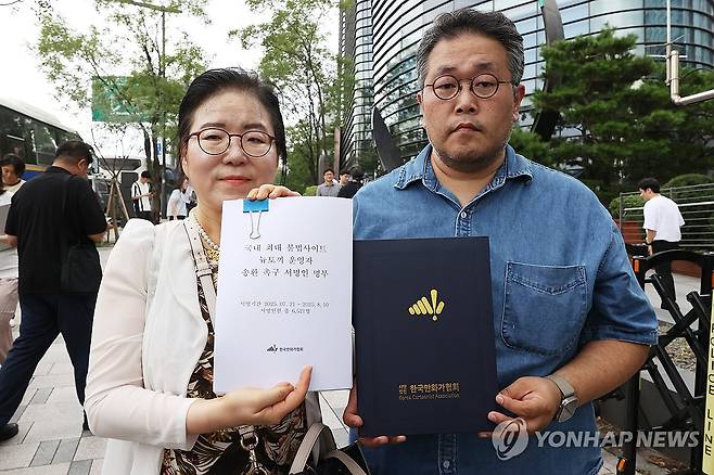 뉴토끼 운영자 국내 송환 촉구 서명 전달 (서울=연합뉴스) 강민지 기자 = 신일숙 한국만화가협회장(왼쪽), 권혁주 한국웹툰작가협회장이 11일 서울 종로구 주한 일본대사관 앞에서 열린 불법 웹툰 사이트 '뉴토끼' 운영자 국내 송환 기자회견을 마치고 서명인 명부 전달을 위해 들고 있다. 2025.8.11 mjkang@yna.co.kr
