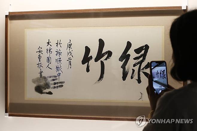 안중근 의사 유묵 '녹죽' (서울=연합뉴스) 강민지 기자 = 11일 서울 중구 덕수궁 돈덕전에서 열린 특별전 '빛을 담은 항일유산' 언론 공개회에서 관계자가 안중근 의사의 유묵 '녹죽'을 살펴보고 있다. 전시는 근대기 항일 독립유산을 통해 광복의 의미를 조명한다. 2025.8.11 mjkang@yna.co.kr