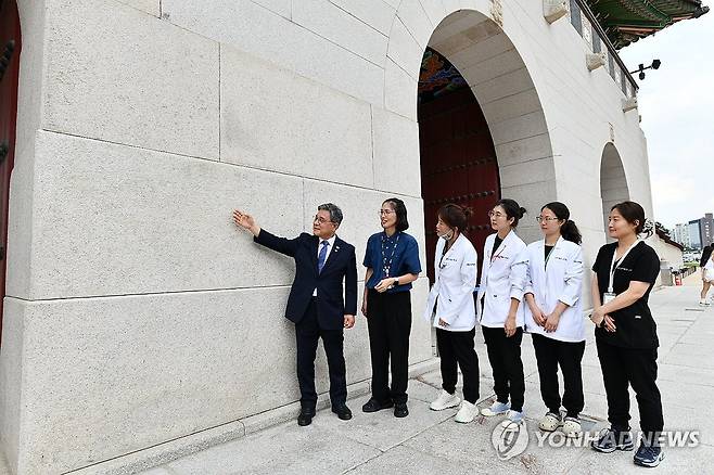 낙서 제거 완료된 경복궁 광화문 석축 확인하는 허민 국가유산청 (서울=연합뉴스) 허민 국가유산청장이 11일 서울 경복궁 광화문 석축에서 낙서 제거 작업이 완료된 현장을 국립고궁박물관 유물과학과 보존처리팀 관계자들과 함께 확인하고 있다. 2025.8.11 [국가유산청 제공. 재판매 및 DB 금지] photo@yna.co.kr