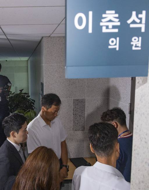 주식 차명거래 혐의를 받는 이춘석 의원의 국회 사무실에 11일 서울경찰청 금융범죄수사대 전담수사팀 관계자가 도착해 의원실 관계자와 압수수색 영장 집행을 두고 대화하고 있다. 연합뉴스
