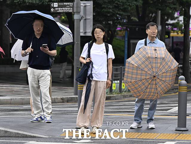 화요일이자 12일은 남부지방 중심으로 비가 내리겠다. 남해안은 시간당 10~30㎜의 강한 비가 내리는 곳이 있을 것으로 예보됐다. 낮 최고기온은 33도로 무더울 전망이다. 사진은 서울 중구 청계천 인근 시민들이 우산을 접어 들고 있는 모습. /장윤석 기자