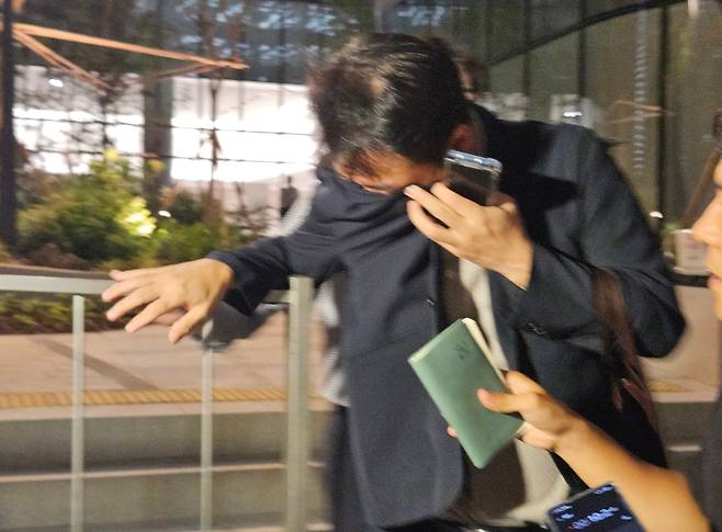 김건희 여사 오빠인 김진우 씨가 지난달 28일 김 여사 관련 의혹들을 수사하는 민중기 특별검사팀 사무실이 위치한 서울 종로구 KT광화문빌딩에서 조사를 마친 뒤 얼굴을 가린 채 특검 사무실을 나서고 있다. /연합뉴스