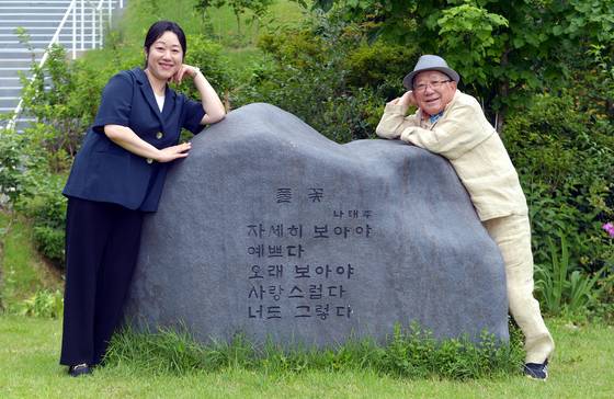 나태주 시인과 딸 나민애 서울대 교수가 80주년 광복절을 앞두고 충남 공주에 있는 '나태주 풀꽃문학관'에서 나태주 시인의 대표작인 '풀꽃' 시비를 배경으로 정감어린 포즈를 취한 모습. 김성태 객원기자