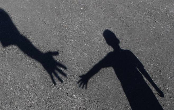 An image shows a child reaching out to seek help. [SHUTTERSTOCK]