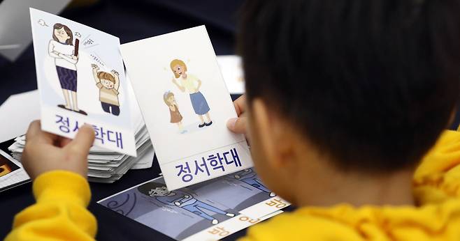 A child holds cards depicting child abuse at an event to prevent child abuse in Sejong in 2019. [NEWS1]