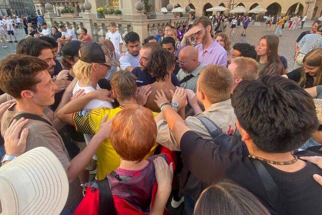 공연을 마친 뒤 복음에 마음을 연 한 관객의 어깨에 손을 얹고 합심기도하는 EI 청년들의 모습. EI 제공