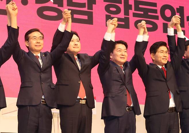 12일 오후 부산 해운대구 벡스코에서 열린 국민의힘 부울경 합동연설회에서 당대표 후보들이 손을 맞잡고 있다. 왼쪽부터 조경태, 장동혁, 안철수, 김문수 후보. [사진 = 사진공동취재단]