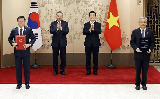김동철(오른쪽 첫번째) 한국전력공사 사장과 레 마잉 훙(왼쪽 첫번째) 베트남 에너지 산업공사(PVN) 회장이 11일 서울 용산 대통령실 청사에서 이재명(오른쪽 두번째) 대통령과 또 럼 베트남 당 서기장이 임석한 가운데 열린 양해각서(MOU) 서명식에서 기념촬영을 하고 있다. [연합]