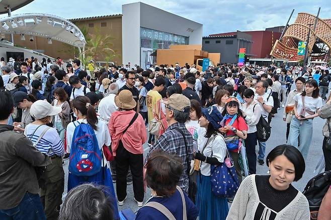 지난 5월 21일(현지시간) 일본 오사카시에서 열린 2025오사카·간사이 만국박람회(오사카 엑스포)의 여러 전시관 앞에 사람들이 줄을 서서 입장을 기다리고 있다.[AFP]