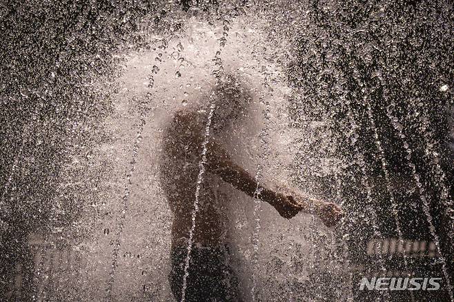 [부쿠레슈티(루마니아)=AP/뉴시스]루마니아 부쿠레슈티에서 지난 7월25일 폭염을 견디지 못한 한 남성이 분수대에 뛰어들어 물을 맞고 있다. 올해 7월은 지구상에서 가장 더운 달이었다고 '유럽연합(EU)의 코페르니쿠스 기후변화서비스'가 8일 공식 발표했다. 2023.08.08.