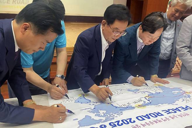 12일 오후 2시 전북도청 공연장에서 열린 '신통일한국 피스로드 2025 전북도 통일대장정' 행사에서 주요 참석자들이 피스로드 배너에 서명하고 있다. 전주=김동욱 기자
