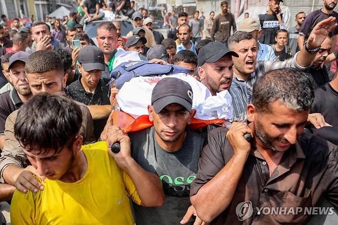 11일(현지시간) 이스라엘의 공습으로 사망한 알자지라 취재진의 시신을 운구하는 모습. [AFP 연합뉴스. 재판매 및 DB 금지]