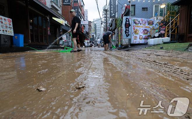 13일 오후 서울 은평구 연신내역 인근 상가 거리에서 상인들이 폭우로 인해 더러워진 거리를 청소하고 있다. 2025.8.13/뉴스1 ⓒ News1 이승배 기자