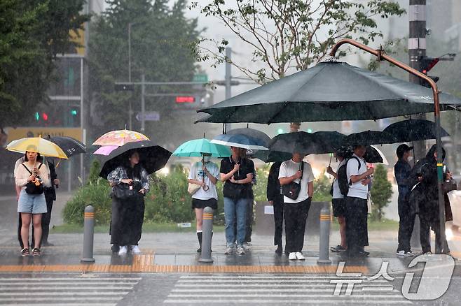 서울에 호우주의보가 내린 13일 서울 종로구 광화문네거리에서 우산을 쓴 시민들이 신호를 기다리고 있다. 2025.8.13/뉴스1 ⓒ News1 민경석 기자