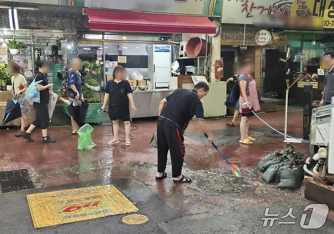 13일 오후 2시30분쯤 찾은 인천 서구 강남시장 상인들이 거리에 나와 쌓인 흙과 쓰레기들을 치우고 있다.이시명 기자/뉴스1