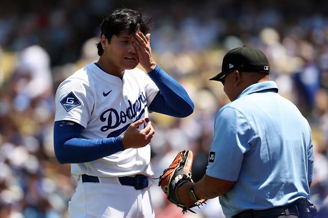 LA 다저스 오타니 쇼헤이가 지난 7일(한국시각) 세인트루이스 카디널스전에 선발등판해 4회 투구를 마치고 심판으로부터 글러브 이물질 검사를 받고 있다. Imagn Images연합뉴스