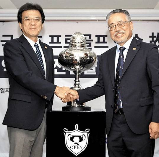 김원섭(오른쪽) KPGA 회장과 야마나카 히로시 JGA 최고운영책임자가 12일 연덕춘 전 고문의 일본오픈 기록 정정 기념식에서 악수하고 있다. 트로피는 이번에 복원했다. /KPGA