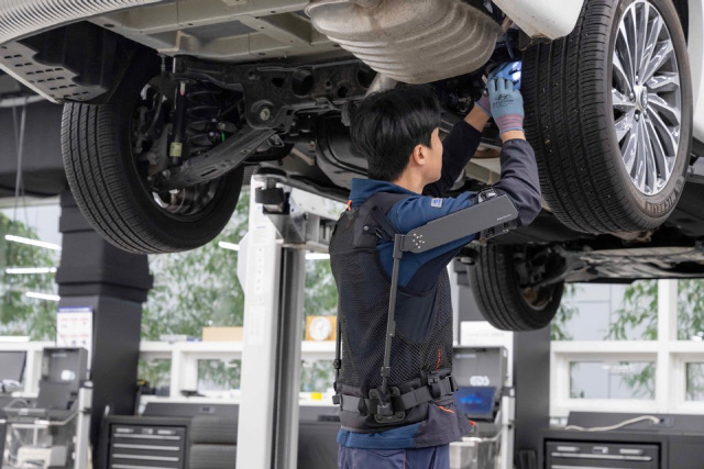 현대차·기아 로보틱스랩이 개발한 웨어러블 로봇 ‘엑스블 숄더’를 착용하고 작업자가 작업을 하고 있다. 현대차·기아 제공