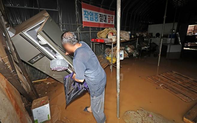 13일 인천 계양구 병방동의 한 조경 자재창고에서 관계자가 흙탕물에 젖은 가재도구를 정리하고 있다. 연합뉴스