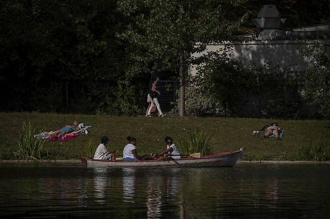 [파리=AP/뉴시스] 12일(현지 시간) 프랑스 파리 라크 도메닐 강에서 시민들이 휴식하고 있다. 2025.08.13.