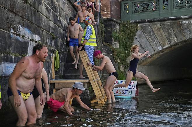 [베를린=AP/뉴시스] 12일(현지 시간) 독일 베를린에서 시민들이 슈프레강 수영 금지 해제를 촉구하며 강에서 수영하고 있다. 슈프레강은 수질 오염에 따른 보건 위험으로 100년 넘게 수영이 금지됐다. 시민 단체 등은 슈프레강이 수영할 만큼 수질이 개선됐다면서 수영 허용을 촉구하고 있다. 2025.06.18.