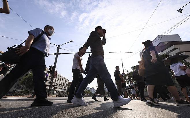 지난달 30일 오전 서울 서초구 고속버스터미널 인근에서 시민들이 강하게 내리쬐는 햇볕을 피해 출근길에 나서고 있다. 뉴시스