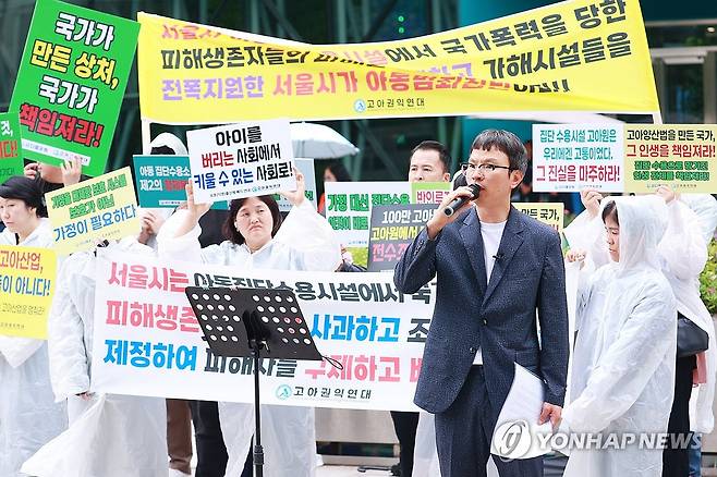 "국가가 만든 상처, 국가가 책임져라"  고아권익연대 관계자들이 6월 25일 오후 서울 시청 앞에서 서울시 아동집단수용시설 피해생존자 피해 보상 촉구 기자회견을 하고 있다. 마이크 잡고 연설하는 사람은 조윤환 고아권익연대 대표.
[연합뉴스 사진]