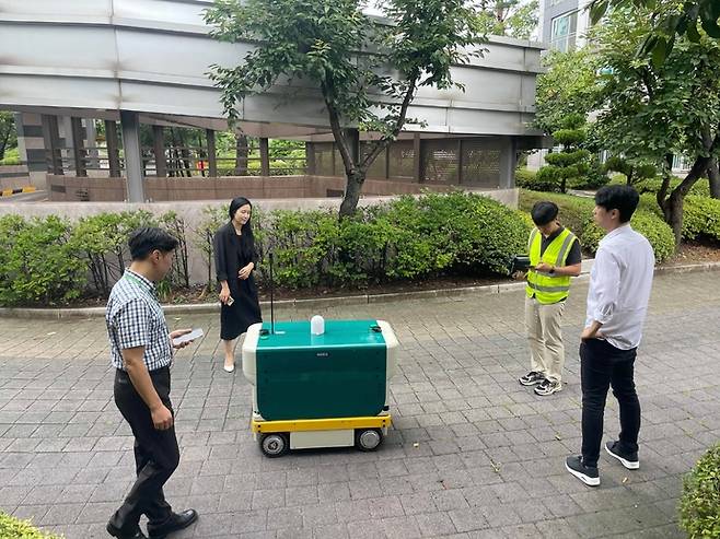 13일 광교한양수자인아파트에서 관계자들이 '지능형 로봇 방범 및 택배 새벽배송' 실증사업과 관련한 현장 점검 및 시연을 진행하고 있다. 사진=수원시청