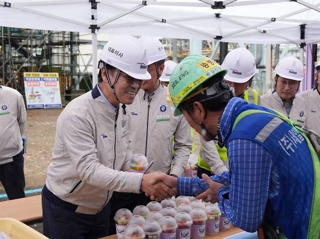 이용배 현대로템 사장이 14일 당진제철소 내에 위치한 3코크스 건식소화설비(CDQ) 건설현장에 마련된 빙수차 앞에서 근로자들에게 컵빙수를 전달하고 있다. 현대로템 제공