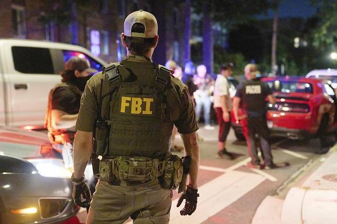 12일 미국 워싱턴에 배치된 연방수사국(FBI) 요원이 거리를 순찰하며 주차구역을 어긴 시민을 단속하고 있다. 전날 도널드 트럼프 대통령은 워싱턴의 치안이 “통제 불능”이라며 주방위군 800명과 FBI 등 연방 요원 500명을 워싱턴에 투입하겠다고 밝혔다. 워싱턴=AP 뉴시스