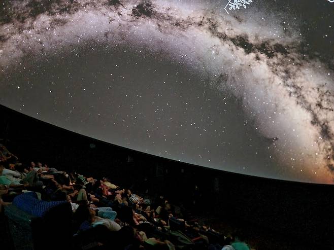 국립광주과학관 '2025 돔 영화제' 참가자들이 천체투영관에서 별자리 해설을 듣고 있다.