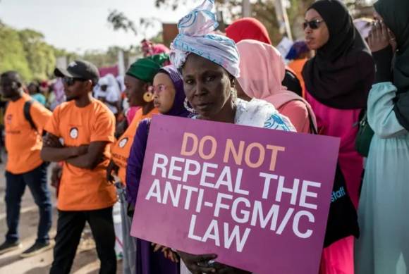 지난해 3월 감비아 수도 반줄의 국회 밖에서 여성 할례 금지 해제 법안에 대한 의원들의 토론이 진행되는 동안 한 여성이 할례에 반대한다는 손팻말을 들고 있다. [사진=AFP/연합뉴스]