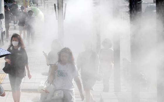 14일 부산지방 낮최고 기온이 32도를 기록하는 등 남부지방에 폭염이 기승을 부리고 있다. 사진은 시민들이 부산 동구 부산진역 인근에 설치된 쿨링포그를 맞으며 지나고 있다. 송봉근 기자