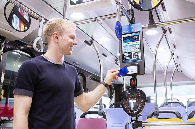 외국인 관광객이 제주 시내버스에서 비자 카드를 탭하여 승차하고 있다. 비자가 이달 13일 제주도에 도입한 개방형 교통결제 시스템(Open-loop Transit)으로 교통카드를 새로 구매하거나 충전할 필요 없이 외국인이 자국에서 사용하던 비자 카드로 버스를 이용할 수 있게 됐다. 비자코리아 제공