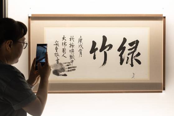 A visitor photographs activist Ahn Jung-geun's calligraphy at the Korea Heritage Service's special exhibition titled “The Radiant Heritage of Independence” at Deoksu Palace in Jongno District, central Seoul, on Monday. [JOONGANG ILBO]