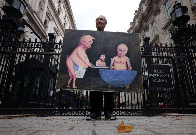 풍자화 작가 카야 마르가 13일(현지시간) 영국 런던 다우닝가에서 자신의 작품을 들고 있다. 도널드 트럼프 미국 대통령이 볼로디미르 젤렌스키 우크라이나 대통령을 블라디미르 푸틴 러시아 대통령에게 갖다 바치는 모습이다. EPA연합뉴스