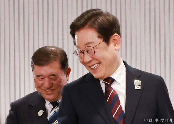 이재명 대통령이 지난 6월17일(현지시간) 캐나다 앨버타주 캐내내스키스 주요 7개국(G7) 정상회의장에서 열린 한일 정상회담에서 이시바 시게루 일본 총리와 자리를 바꾸며 밝게 웃고 있다. / 사진=뉴시스