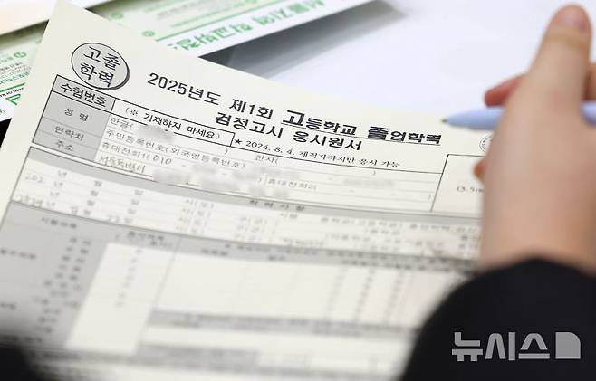 [서울=뉴시스] 지난 2월 17일 서울 동작구 서울공업고등학교 체육관에서 열린 2025년도 제1회 초·중·고 검정고시 응시 원서 접수에서 한 응시생이 응시 원서를 작성하는 모습. 2025.02.17. photo@newsis.com