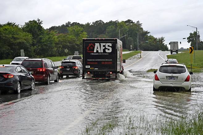 [채터누가( 미 테네시주)= AP/뉴시스] 테네시주를 강타한 역대급 폭우와 돌발 홍수로 8월 12일 채터누가의 간선도로의 차들이 침수된 도로를 조심스럽게 지나가고 있다. 2025. 08.14.
