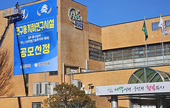 지난해 12월 연구용지하시설(URL)태백유치 확정 환영 대형 현수막이 태백시청 청사에 부착되고 있다.(사진=뉴시스)  *재판매 및 DB 금지