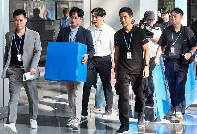 경기남부경찰청과 고용노동부 관계자들이 12일 인천시 연수구 포스코이앤씨 본사 사옥에서 압수품을 담기 위한 박스를 들고 이동하고 있다. /뉴스1