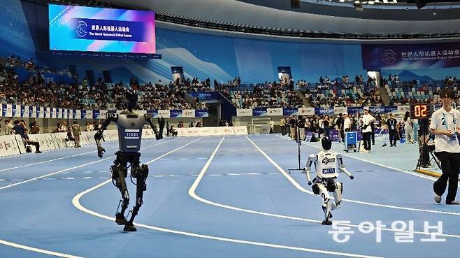 15일 대회 1일차 1500m 종목에 출전한 로봇들은 지난 4월 마라톤 대회에 비해 더 안정적인 자세와 빨리진 속도를 선보였다. 베이징=김철중 특파원 tnf@donga.com