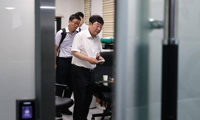 유튜브 채널 '신의한수' 운영자 신혜식 대표가 13일 서울 마포구 사무실에서 윤석열 정부 시절 대통령실의 민간인 시위대 동원 의혹과 관련해 서울경찰청 안보수사과 수사관들에게 휴대전화를 임의제출하고 있다. 연합뉴스