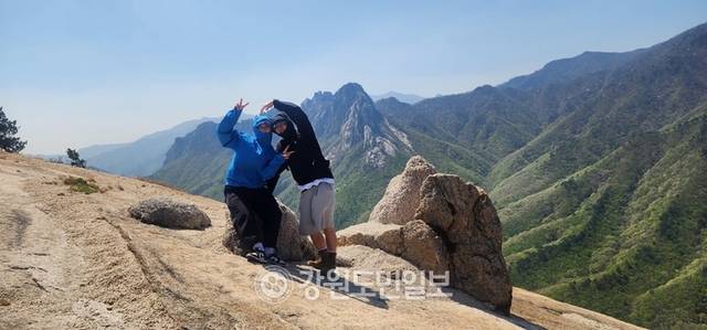 ▲ 금강산 제1봉으로 알려진 화암사 신선대(성인봉). 이곳에서 마주하는 울산바위는 자연이 빚어낸 예술작품이다. 한 연인이 울산바위를 배경으로 하트를 그리고 있다.