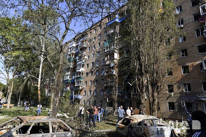 [쿠르스크=AP/뉴시스] 러시아 쿠르스크 주민들이 우크라이나군의 공격으로 파손된 아파트 주변에 모여 있다.  자료사진. 2025.08.15