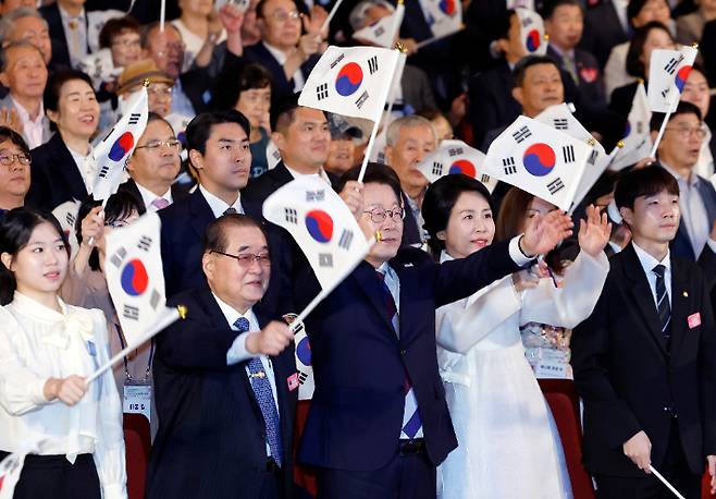 이재명 대통령과 김혜경 여사가 15일 서울 세종문화회관에서 열린 80주년 광복절 경축식에서 참석자들과 만세 삼창을 하고 있다. 연합뉴스